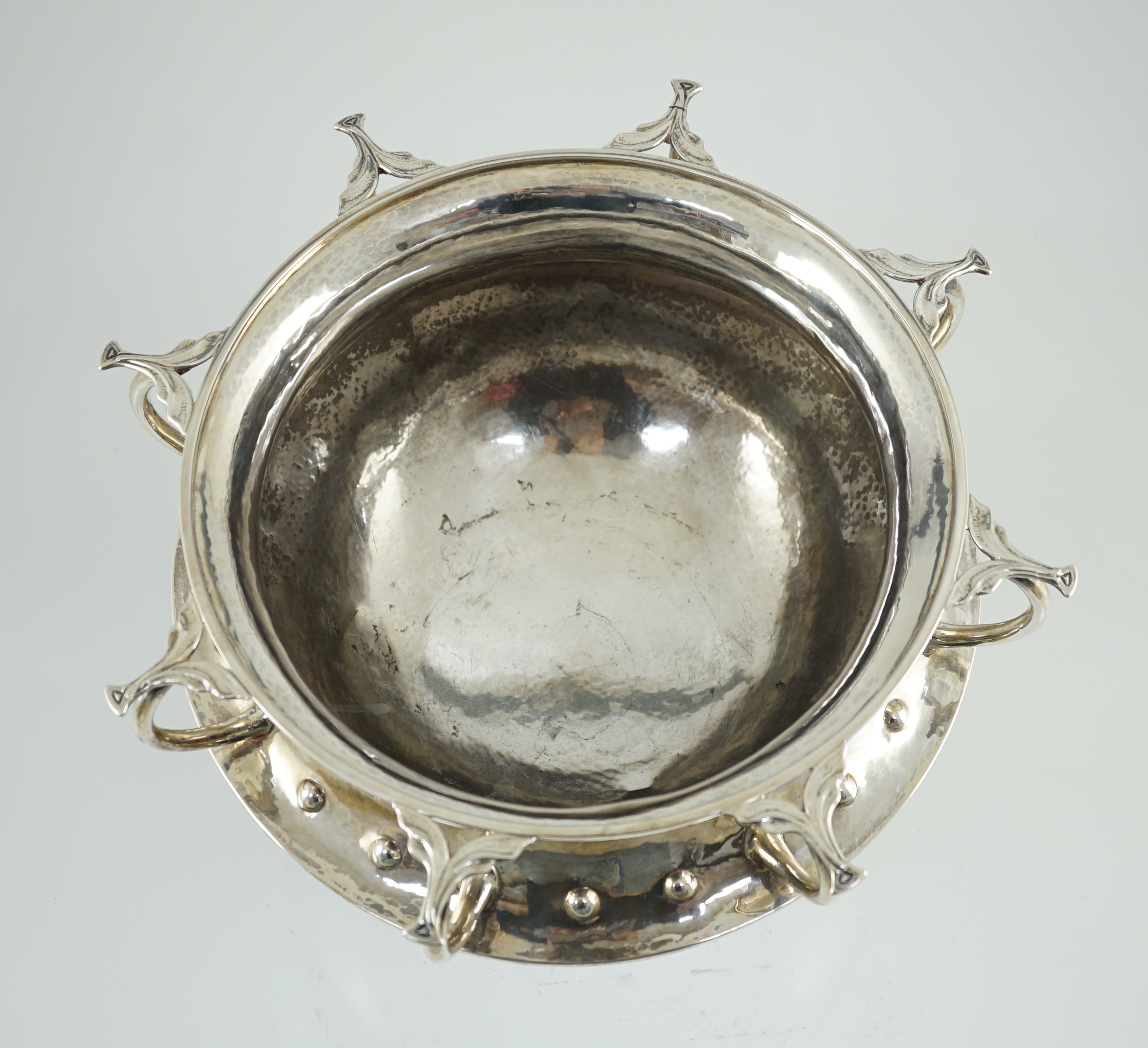 A George V Arts & Crafts planished silver octuple handled pedestal punch bowl, by Albert Edward Jones